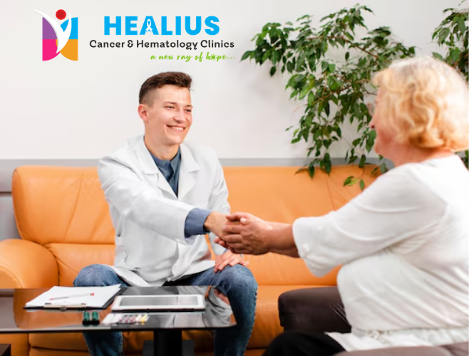 A supportive cancer care specialist at Healius Clinic Bangalore comforting a smiling patient during a consultation.